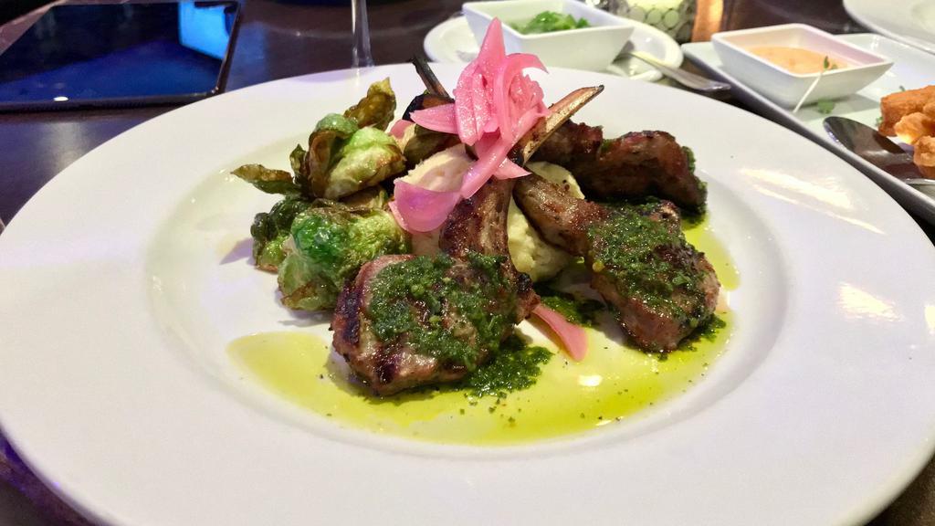Rack of Lamb Churrasco · Tender Australian lamb grilled to your request drizzled with chimichurri sauce, served  with yukon gold mashed potatoes  , sauteed brussels sprouts and pickled red onions