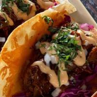 Brisket Tacos · coffee-rubbed, pickled sweet onion, griddled queso, cabbage