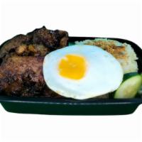 Tapsilog · Marinated beef with garlic topped  rice and sunny-side-up egg.