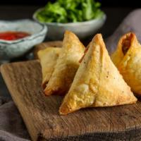 Vegetable Samosa · Two pieces of crispy turnovers with seasoned potatoes and green peas.