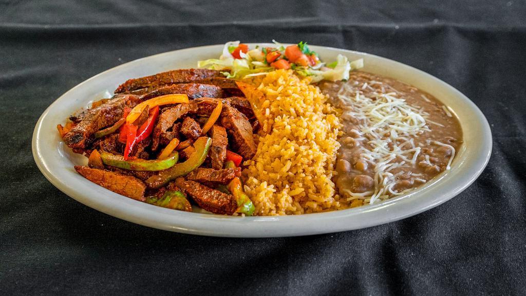 Fajitas · Grilled chicken or steak, with grilled onions and bell peppers. Served with lettuce, pico de gallo, rice, beans, and tortillas.