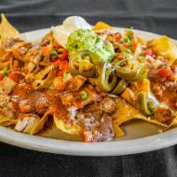 Nachos with Meat · Tortilla chips topped with choice of meat, Monterey Jack cheese, beans, jalapeños, sour crea...