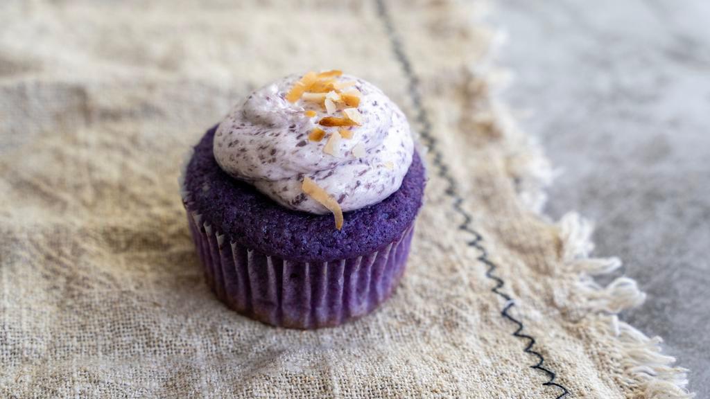 Ube Macapuno (Mini Size) · Ube coconut cake topped with ube buttercream frosting, and garnished with toasted coconut flakes.