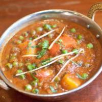 Aloo Matar · Potatoes with green peas, cooked in a tomato based curry.