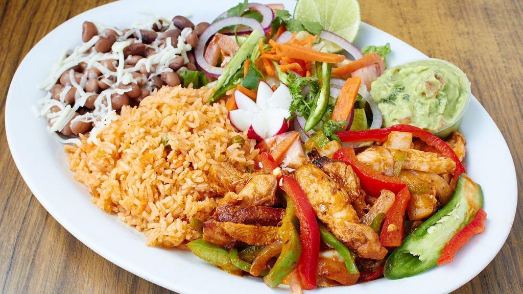 Chile Verde Chicken Dinner · Chicken in green sauce with rice, beans, salad and tortillas.