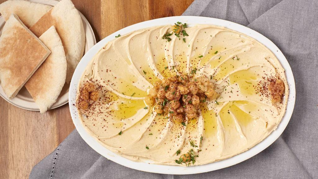 Hummus & Pita · A bowl of Hummus & 2 warmed up, sliced in half pitas.
