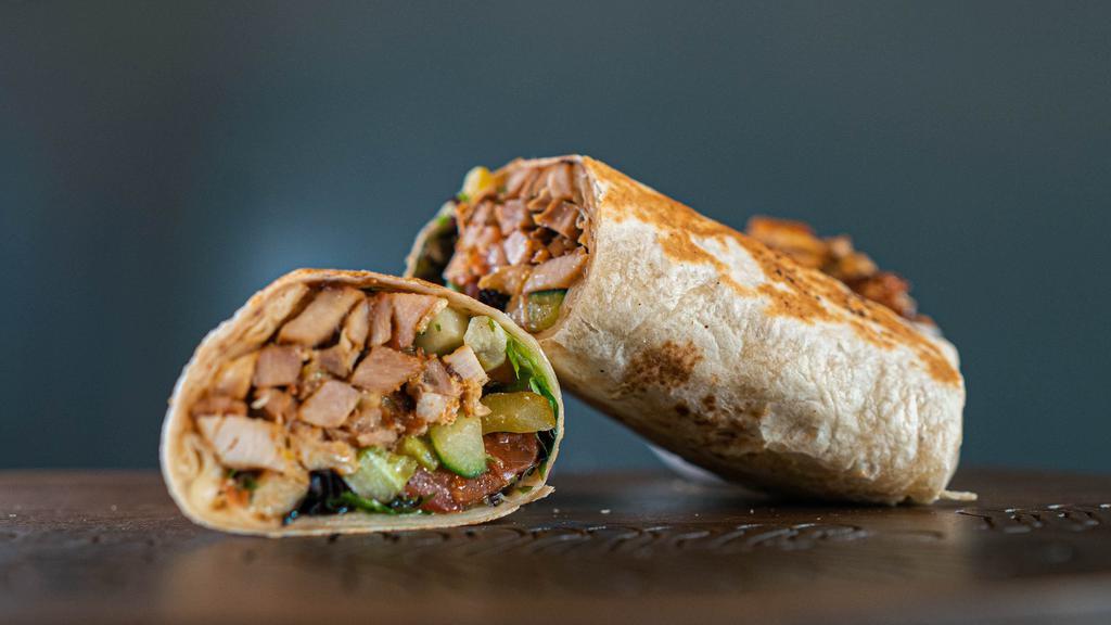 Chicken Shawarma Wrap · All natural raised chicken cooked on a vertical rotisserie served in a fresh lavash wrap, homemade garlic spread, pickles, greens and mediterranean salad.