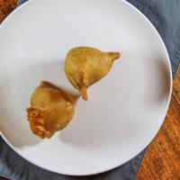 Samosa (2 Pc) · Veggie turnover, stuffed with potatoes, green peas, herbs and spices, served with chutney.