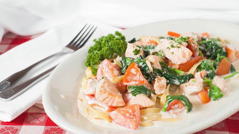 Fresh Salmon Florentine · Pieces of fresh salmon sautéed with garlic, butter, shallots, fresh tomatoes and spinach in a creamy Alfredo sauce - Served with fettuccine