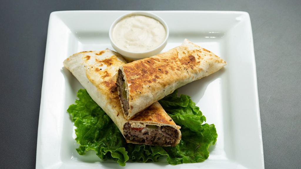 Beef Shawarma Wrap · Shredded Beef, Hummus, Pickles, Red Onions &Tahini Sauce in Lavash. Pressed on the Grill.