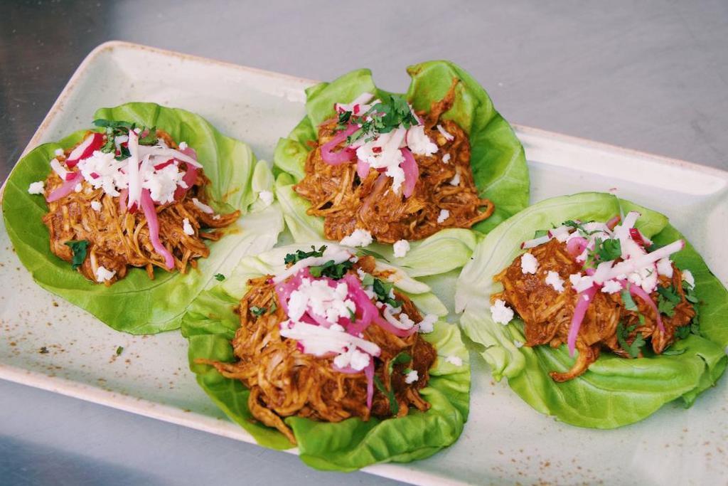 Mole Lettuce Cups · 4 lettuce cups with pitman farms pulled chicken, Oaxacan mole sauce, marinated red onions, radish, cilantro, queso fresco + toasted peanuts *Contains Nuts*