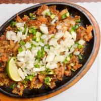 Sizzling Sisig · Crispy pork cheeks and belly, or milkfish, chopped and topped with chopped onions, and jalap...