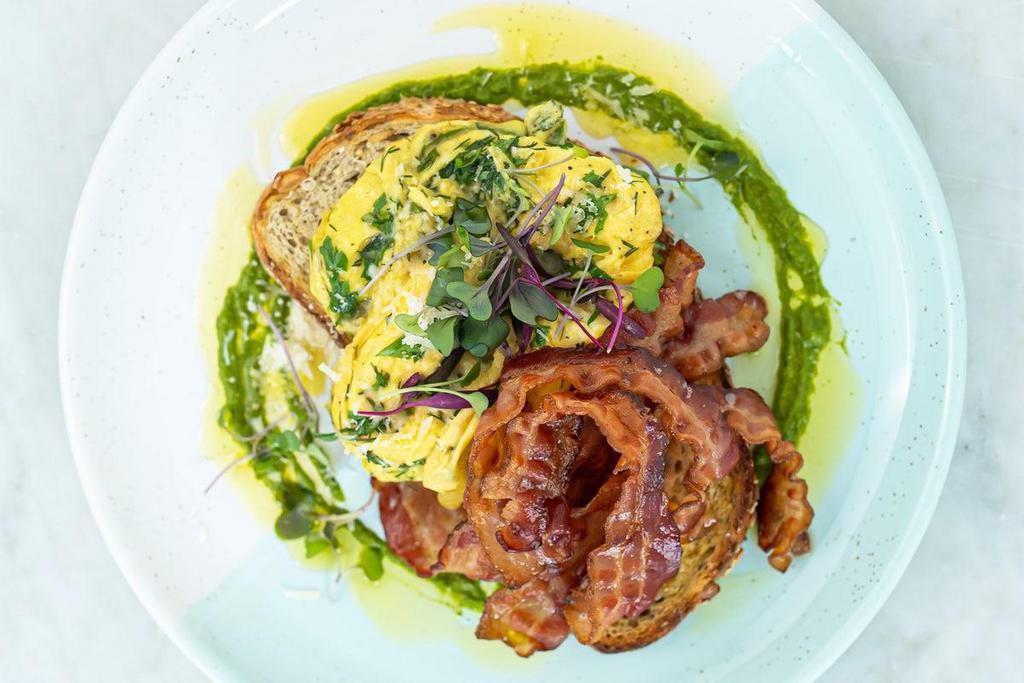 Folded Chimichurri Eggs & Bacon Toast · Crispy bacon and soft folded eggs topped with Parmesan cheese, chimichurri, cracked pepper & fresh herbs on toasted multigrain.. Allergens: G = Contains gluten, D = Contains dairy, E = Contains egg, S = Contains soy, SE = Contains sesame