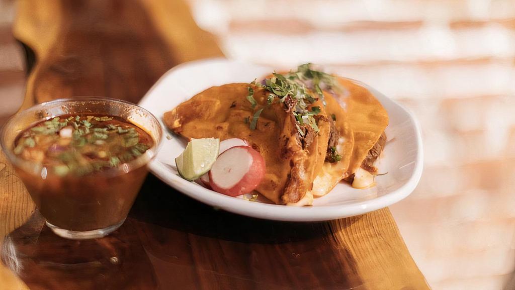 Quesabirria · Three Tortillas dipped in birria consomme stuffed with cheese,onions,cilantro, and shredded birria.