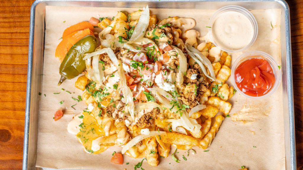 Taco Loaded Fries · Seasoned fries loaded with shredded cheese, house queso, ground beef, pico de gallo, grilled onions, and drizzled with chipotle sour cream.