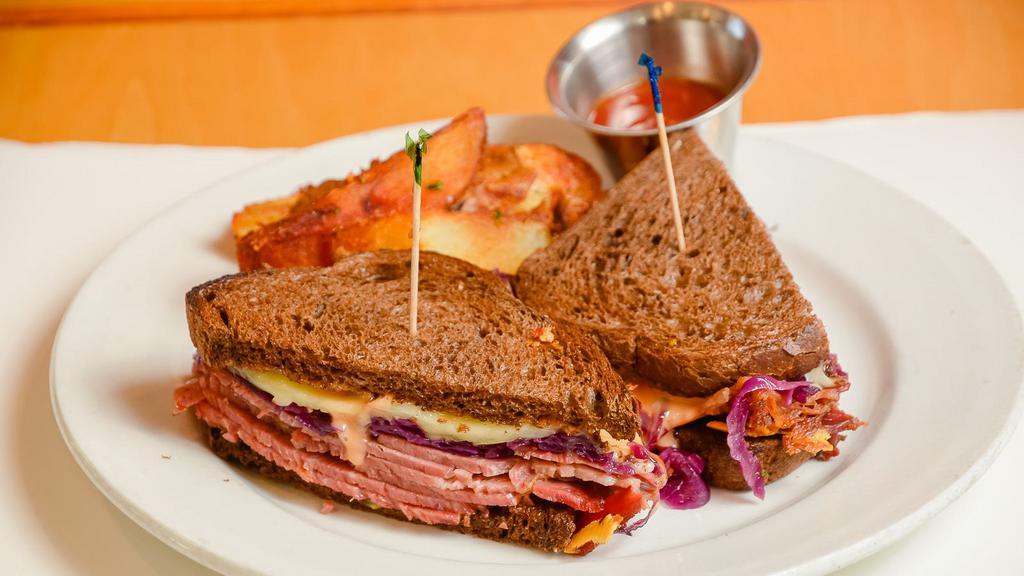 The Park Station · Corned beef sandwich on rye with sweet & sour cabbage, thousand island sauce, swiss cheese, and fries