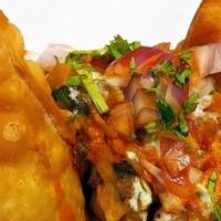 Chaat Samosa · Crispy fried dumplings served with garbanzo curry, topped with chutneys and onion.
