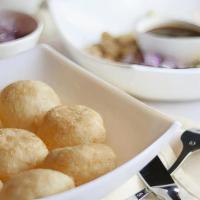 Pani Poori · Crispy puffed wafers served with spicy mint water, chutneys, potatoes, onion, sprouts, and c...
