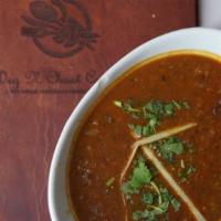 Dal Makhni · Traditional black lentils simmered on low fire with tomato, red chilies, ginger, and garlic.