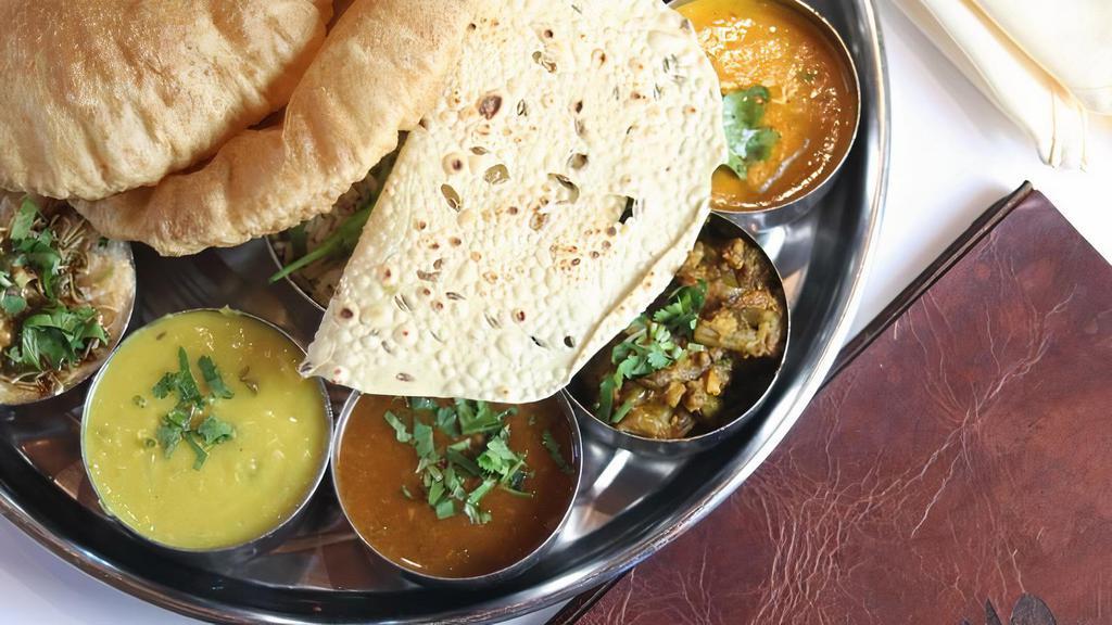 House Thali · Two vegetables, one plain paratha or two rotis, dal, rice, raita, home-style mint chutney,  papad and kheer with choice of soda, chaas or tea.