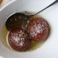 Gulab Jamun · Dry milk and fried cottage cheese dumplings soaked in rose flavored sugar syrup.