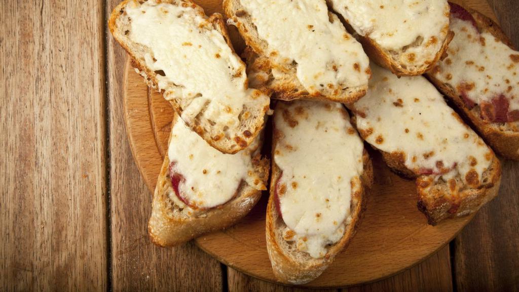 Garlic Bread with Cheese · Fresh baked garlic bread topped with warm mozzarella cheese.