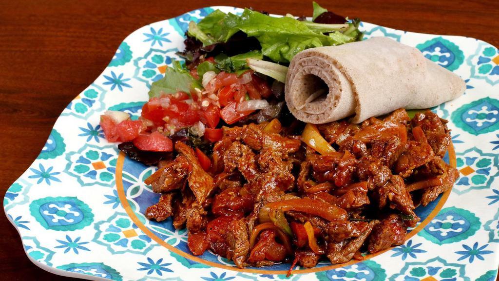 Siga Tibs · Beef marinated and stir-fried with onion, tomato, garlic, and berbere. Add mushrooms and collard greens for an additional charge.