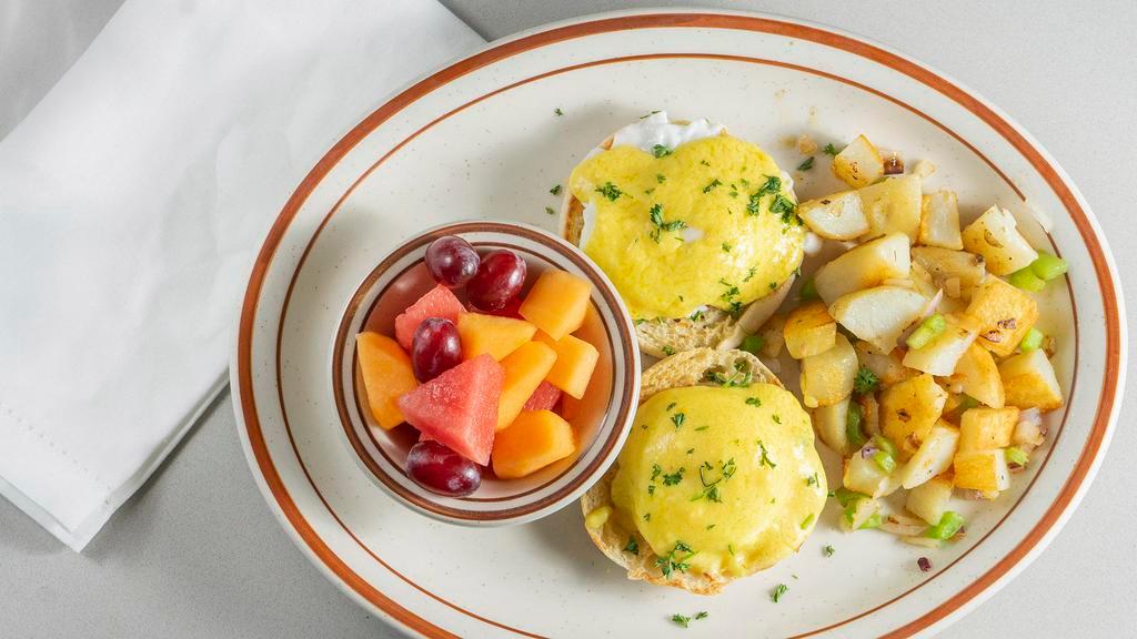 Eggs Benedict · Poached eggs on English muffin, Canadian bacon, topped with hollandaise sauce. also with a side of potatoes and fruits.
