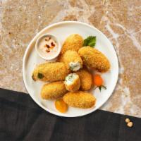 Jalapeno Poppers · Six pieces of crispy golden jalapenos stuffed with creamy cheese and served with savory mari...
