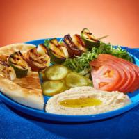 Grilled Veggie Kebab Platter · Onions, zucchini, and eggplant grilled on a skewer. Served with rice or hummus, lettuce, tom...