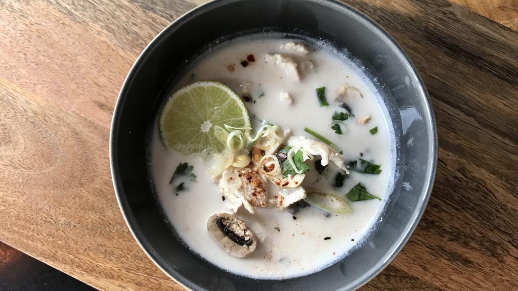 Tom Kha Soup · Spice level 1. Coconut soup with lemongrass, galangal, lime leaves, and white mushroom garnished with cilantros.