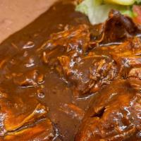 Mole · Chicken cooked in a Special Chocolate Sauce. Served with Rice, Beans, and Tortillas.