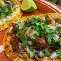 Birria Tacos · Beef slowly simmered in a house-made red broth, served with melted Cheese, Onions, Cilantro,...