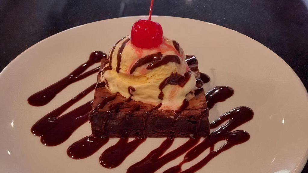 CHOCOLATE CHIP BROOKIE · Part brownie part chocolate chip cookie, served with vanilla ice cream topped with chocolate syrup