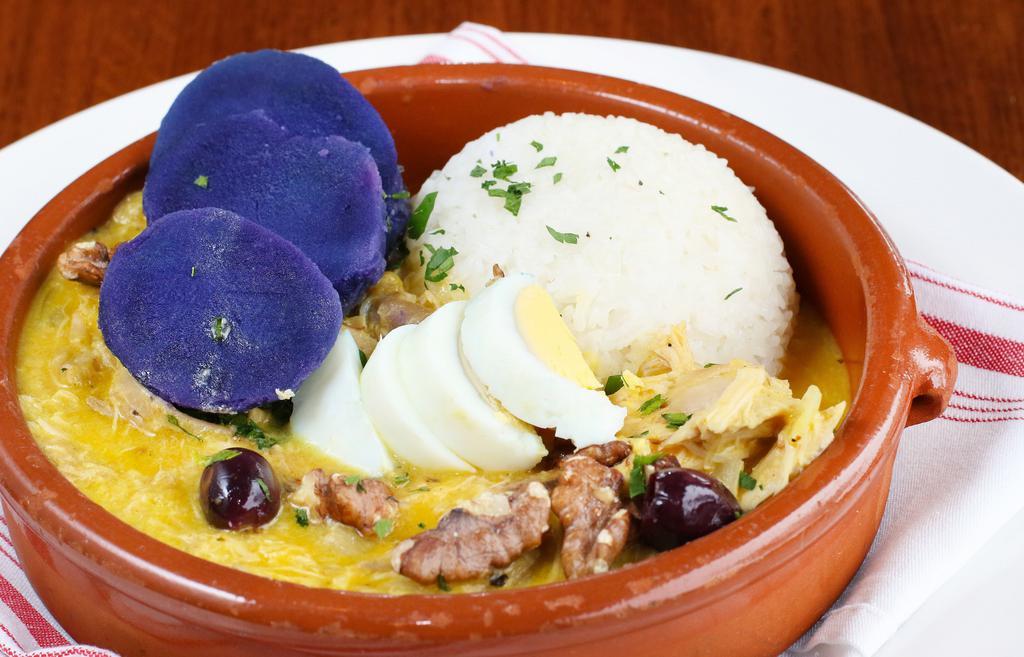 Aji de Gallina (Chicken Stew) · Pulled chicken stew, aji amarillo cream sauce, hard-boiled egg, potato, olives, walnuts, and jasmine rice.
