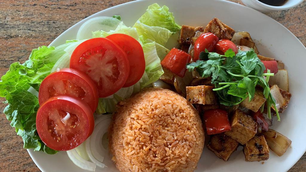Lúc Lắc Chay · Shaking Tofu with Bell Pepper, Garlic & Onion fired up in House Sauce. Served with Seasoned Red Rice Pilaf and Green Leaf, Tomato & Onion
