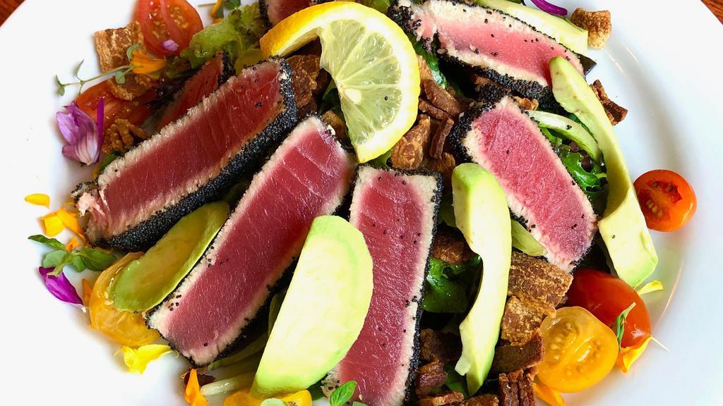 Seared Tuna Salad · Poppyseed crusted yellowfin tuna, mixed greens, red onion, cherry tomatoes, bacon, avocado, and house Dijon vinaigrette.