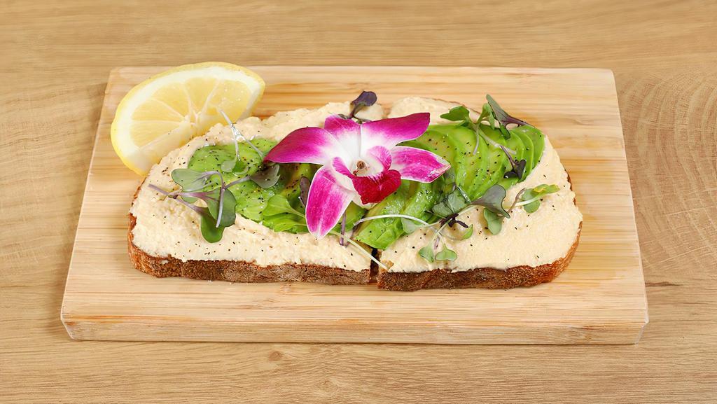 Hummus Toasty · Artisan sourdough bread with our classic hummus, topped with sliced avocado, micro greens, olive oil, salt, pepper & lemon