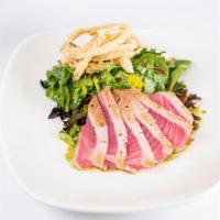 Ginger Ahi Salad · Seared ahi over mixed Asian greens and pickled veggies with a tangy wasabi dressing.