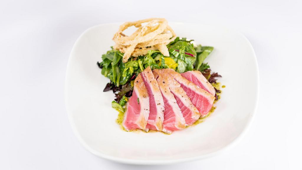 Ginger Ahi Salad · Seared ahi over mixed Asian greens and pickled veggies with a tangy wasabi dressing.