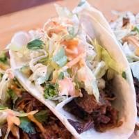 Korean Street Tacos · gojuchang marinated chicken over shredded lettuce and topped with picked daikon, ginger and ...