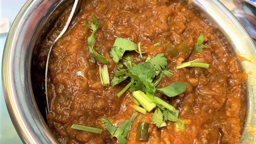 Baingan Bharta · Mashed roasted eggplant sautéed 
 with fresh tomatoes, onions, ginger, green peas, light cream and freshly grounded spices.