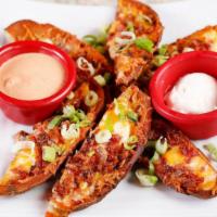 Potato Skins · Baked to a crisp then topped with Cheddar cheese, bacon and green onions. Served with sour c...