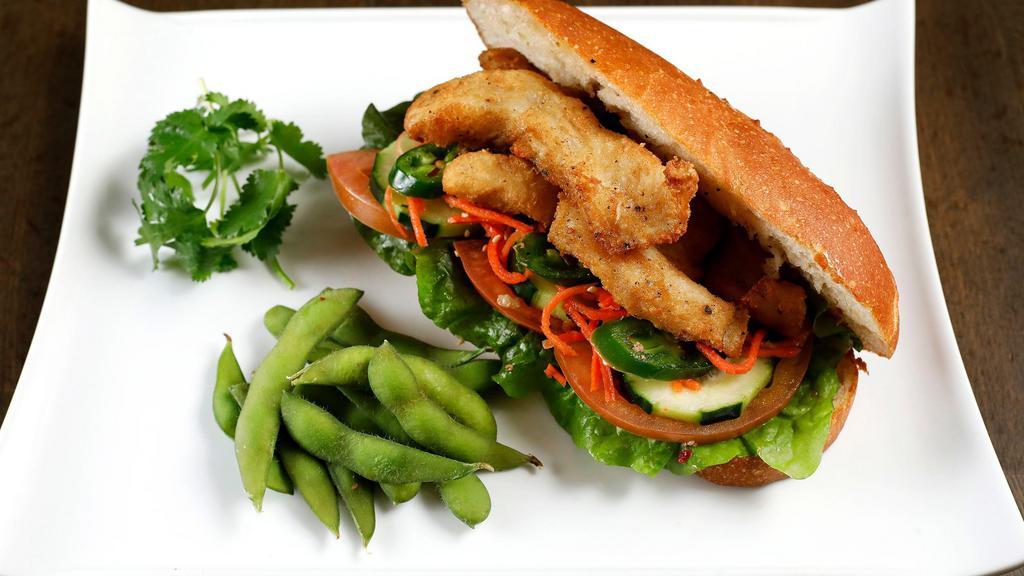 Crispy Basa Sandwich · Crispy white basa fish. Served on an airy French baguette stuffed with home-made aioli, cucumber, tomatoes, carrot, cilantro, jalapeno, and a side of edamame.