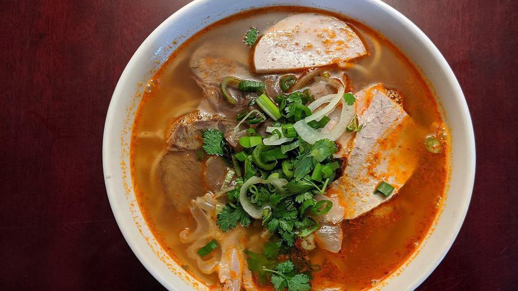 B11. Hue Spicy Noodle Soup (Bún Bò Huế) · One of the most popular dishes from Hue - pork bone spicy broth noodle soup topped with pork, tendon, brisket, and Vietnamese ham.
