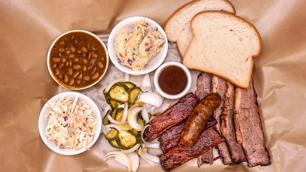 Trinity Combo · Slow-smoked beef brisket, award-winning pork ribs, hot links, beans, potato salad, apple coleslaw, pickles, sweet onions, and white bread. Just like they do it in Austin! (No substitutions please)