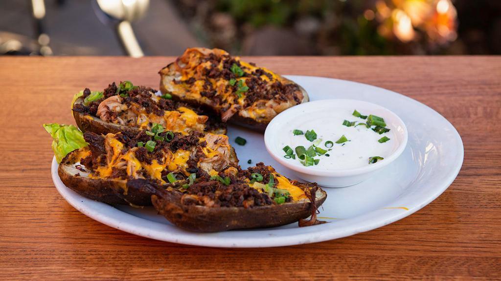 Fully Loaded Pulled Pork Skins · Giant potato skins filled with pulled pork, sour cream onions, cheddar cheese and smoked bacon, topped with green onion. Served with our home-made ranch dressing.