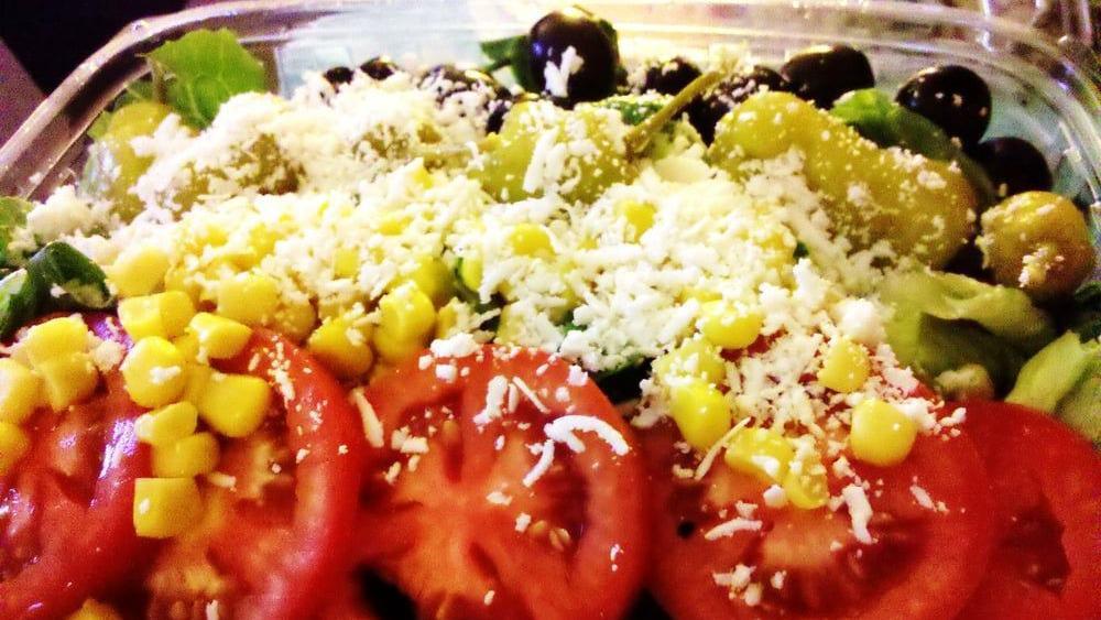Greek Salad · Lettuce, tomatoes, cucumbers, pepperoncini, green pepper, oregano, onion, capers with Greek olives, and feta cheese.