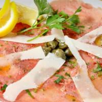 Carpaccio Di Manzo · Raw thin sliced beef eye round with capers, shaved parmigiano, extra virgin olive oil and to...