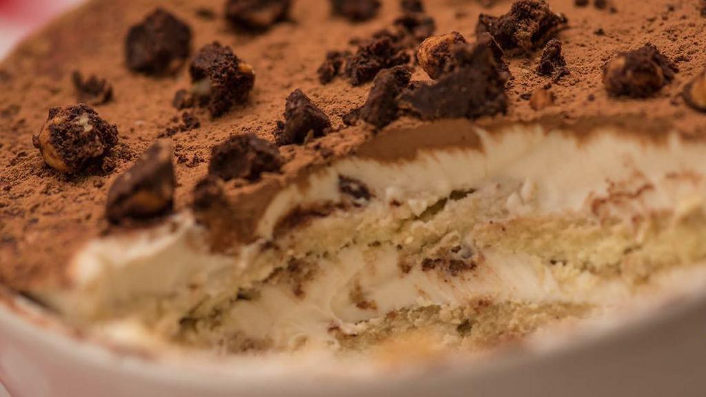 Tiramisu · Our powerfully flavored Tiramisu features homemade ladyfingers soaked in dark rum & espresso, layered with sweetened mascarpone cheese & topped with cocoa & crumbled hazelnut biscotti